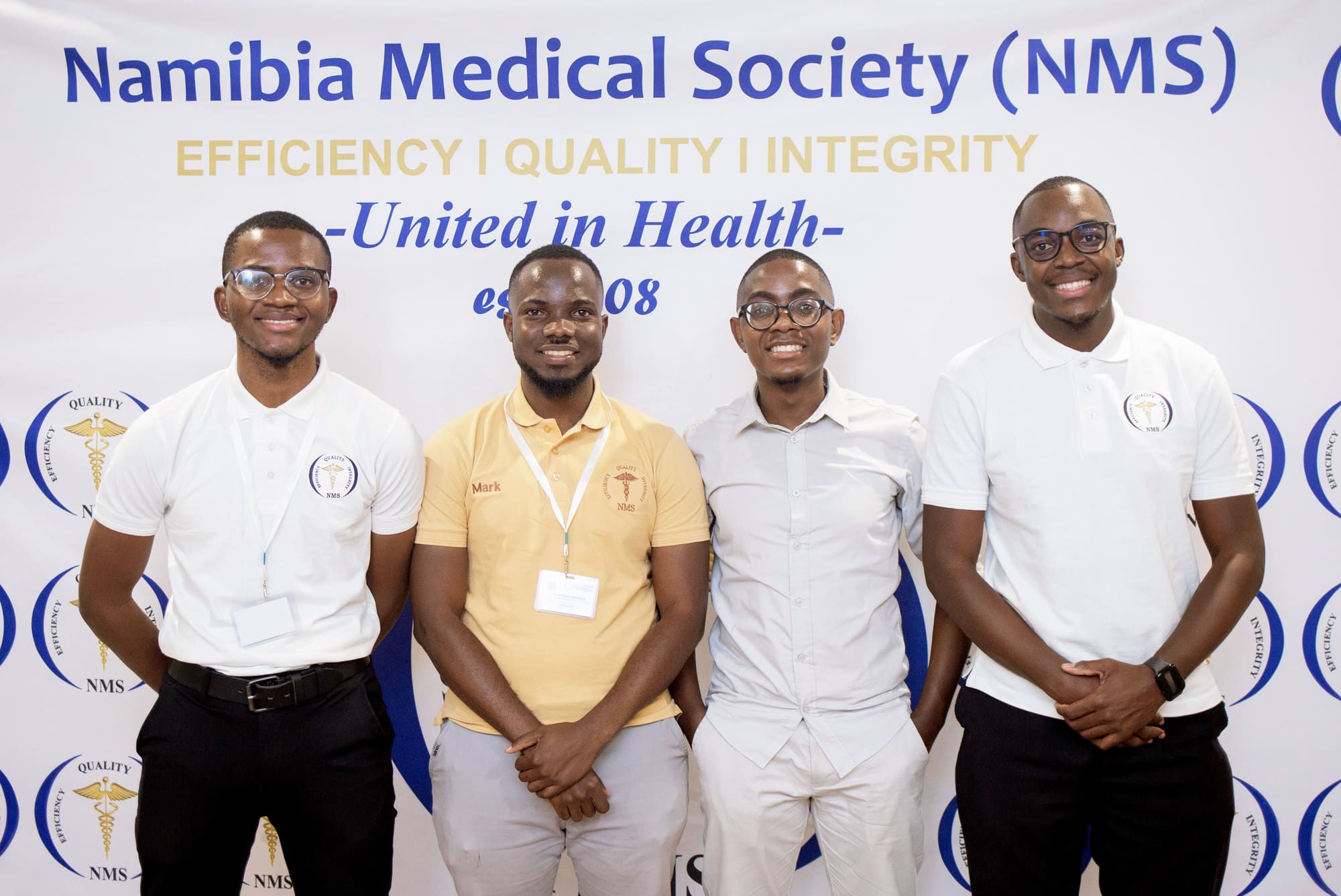 Four NMS members standing together in front of a Namibia Medical Society backdrop.